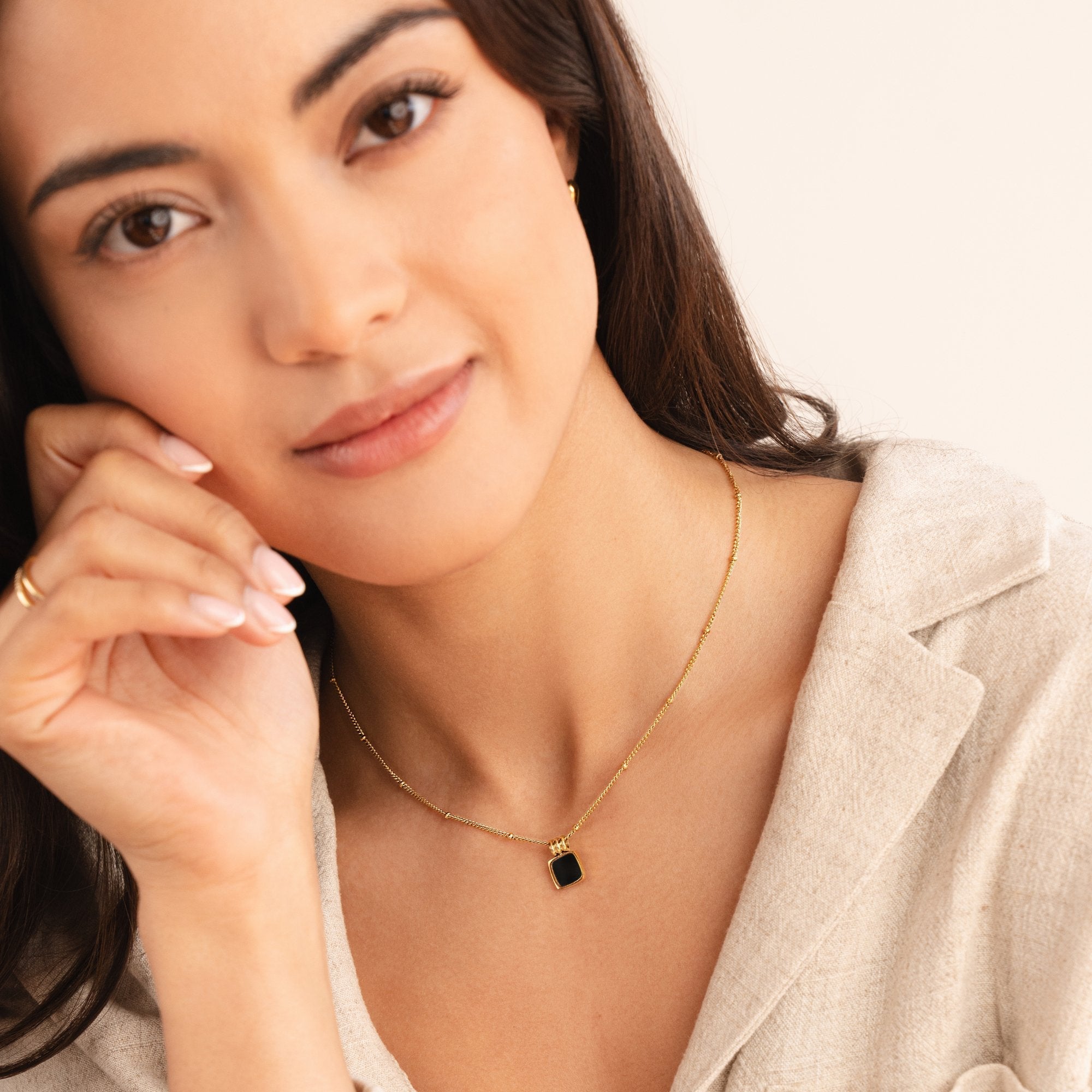 セリーナ – ダークストーンのゴールドネックレス。